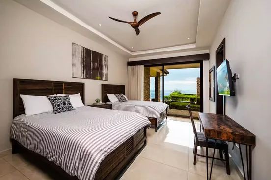 Room with two queen beds opening onto a terrace and the ocean view