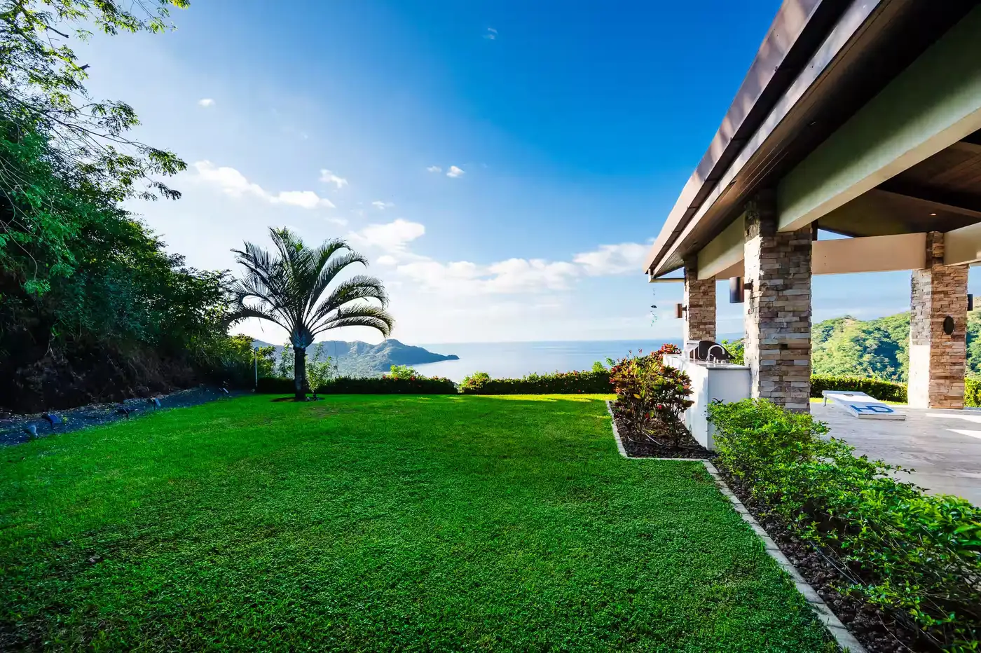 Lawn and covered terrace at the villa, looking out over the Pacific