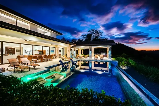 The villa's pool and terrace lit at dusk