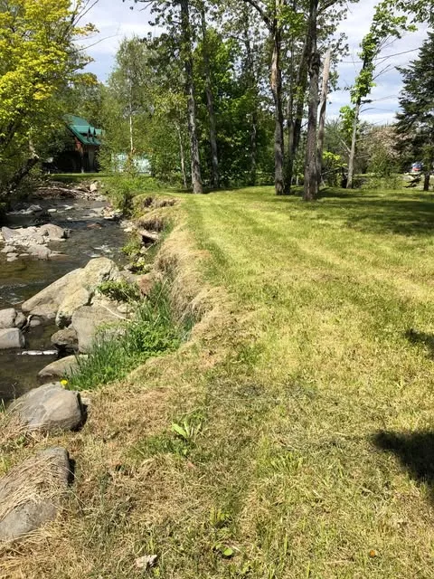 The lodge seen across the lawn, with the creek running along its edge